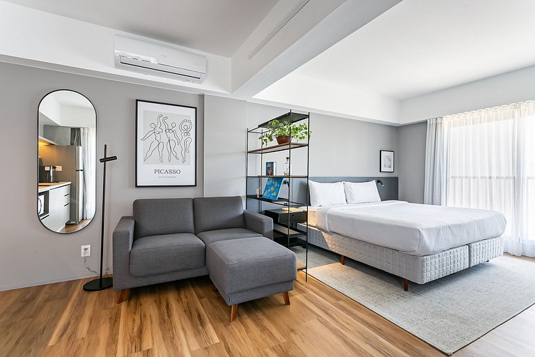 Estúdio com cama king-size, prédio com academia