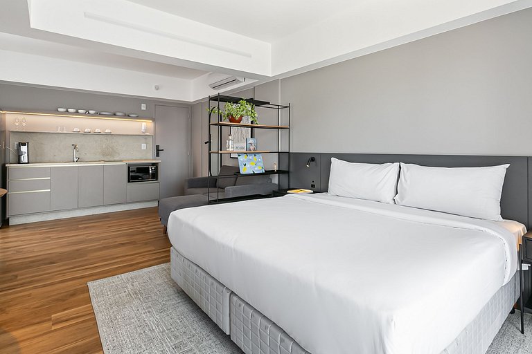 Estúdio com cama king-size, prédio com academia